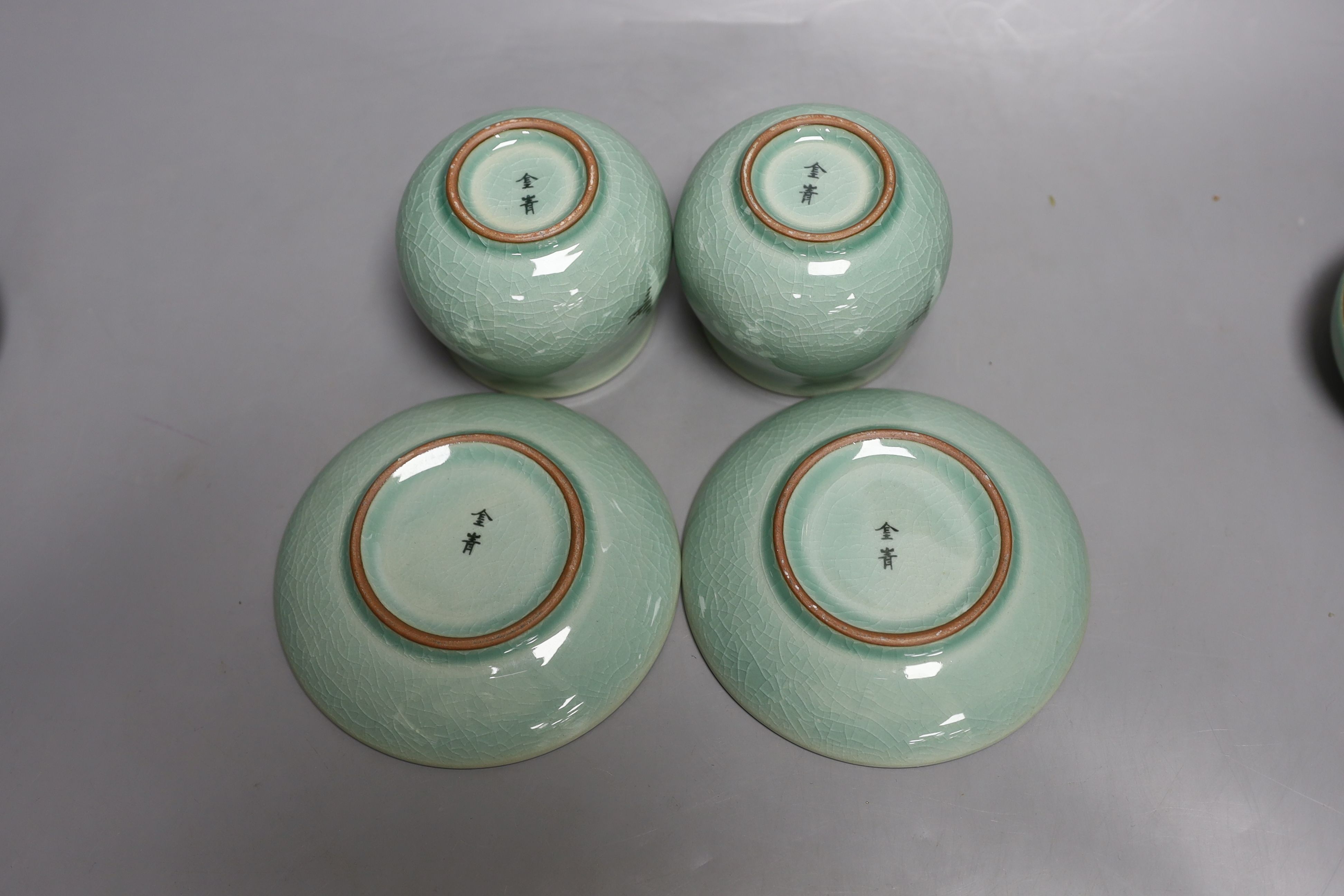 A pair of Korean green glazed pottery tea bowls, cover and stand with strainer each inside - 11cm tall